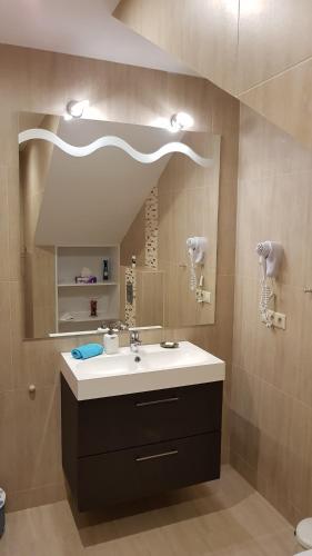a bathroom with a sink and a mirror at Tündérlak Vendégház in Balatonfüred