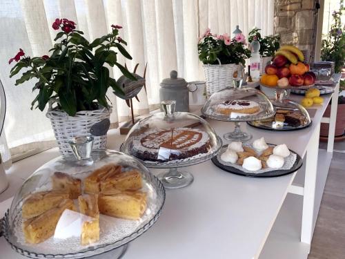 een tafel met verschillende bakken brood en gebak erop bij La Cascata Negli Ulivi in Toscolano Maderno