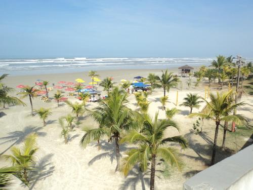 an aerial view of a beach with palm trees and umbrellas at Sarau's Beach House Boracéia in Boracéia