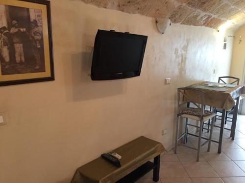 a tv on a wall with a table and a stool at Sea Home 2 in Monopoli