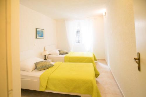 2 Betten in einem kleinen Zimmer mit gelber Bettwäsche in der Unterkunft Stella del Mare Apartment - Dubrovnik Old Town Getaway in Dubrovnik