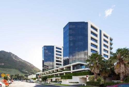 a tall building with palm trees in front of a street at Ocean Eleven 5 in Mount Maunganui