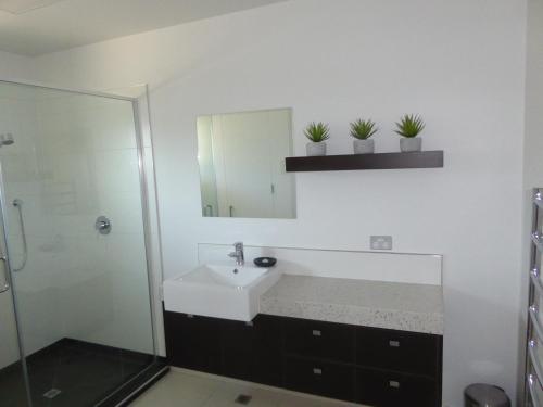 a bathroom with a sink and a mirror at Luxury Waterfront Apartment - Quay No 6 in Picton