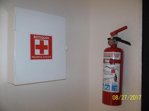 a fire hydrant is next to a wall with a sign at La Casa del Chac in Mérida