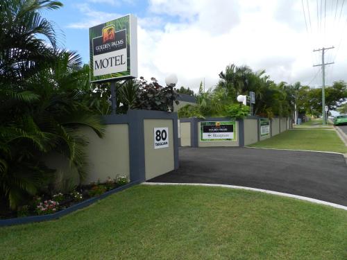 a motel sign in front of a driveway at Golden Palms Motor Inn in Bundaberg