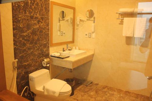 a bathroom with a white toilet and a sink at Muong Thanh Cua Dong Hotel in Vinh