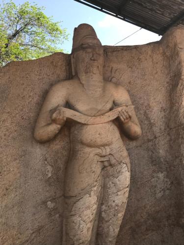 a stone statue of a man holding at Disna Homestay in Habarana