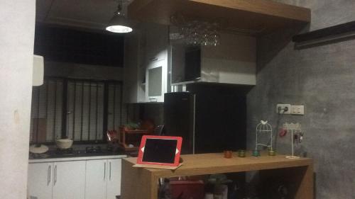 a kitchen with a red laptop on a table at Roemah Abdoe in Arau