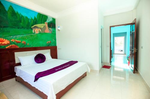a bedroom with a bed with a painting on the wall at Dang Quang Guesthouse in Ha Long