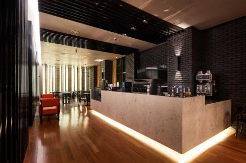 a lobby with a bar with a red chair at Hotel Venue-G Seoul in Seoul