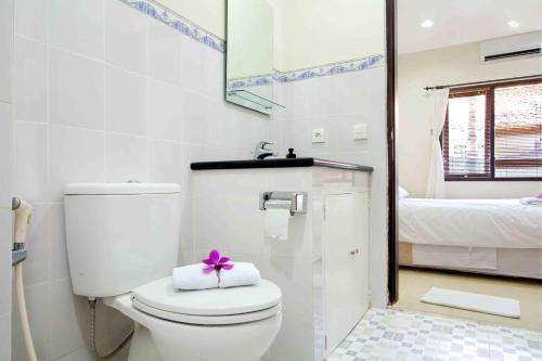 baño con aseo con arco morado en Bali Paradise Apartments, en Sanur