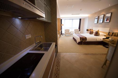 a kitchen with a sink and a bedroom with a bed at Suzhou Sun Plaza Hotel in Suzhou