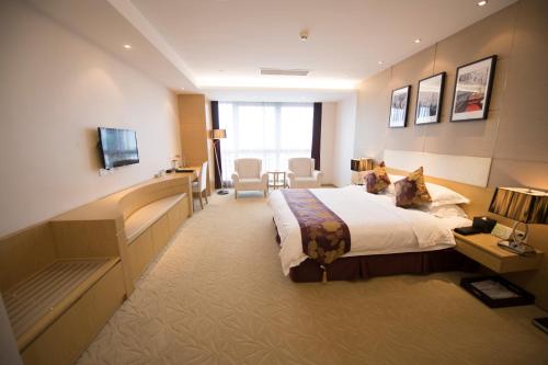 a hotel room with a bed and a television at Suzhou Sun Plaza Hotel in Suzhou