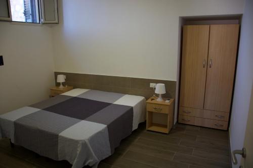 ヴィエステにあるAppartamenti Posta del Soleの小さなベッドルーム(ベッド1台、キャビネット付)
