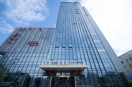 a tall building with a sign in front of it at Suzhou Sun Plaza Hotel in Suzhou