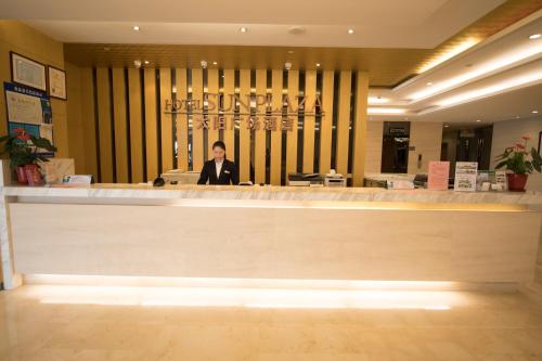a man standing behind a counter in a store at Suzhou Sun Plaza Hotel in Suzhou