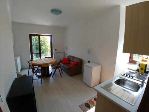 a kitchen and living room with a table and a sink at Agriturismo Bastià in Corio