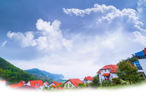 a group of houses with mountains in the background at Namhae Frankfurt Pension in Namhae