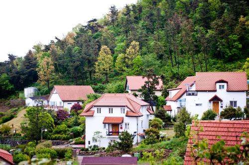 a row of white houses in front of a mountain at Namhae Frankfurt Pension in Namhae