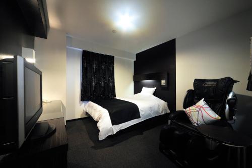 a bedroom with a bed and a flat screen tv at Green Rich Hotel Iwakuni Ekimae (Artificial hot spring Futamata Yunohana) in Iwakuni