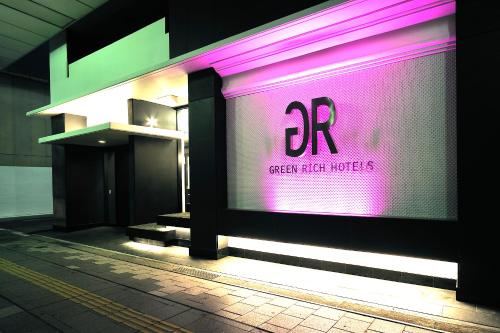 a building with a pink sign on the side of it at Green Rich Hotel Iwakuni Ekimae (Artificial hot spring Futamata Yunohana) in Iwakuni