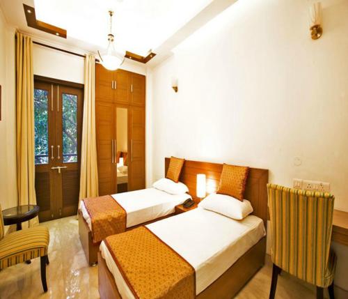 a hotel room with two beds and a table and chairs at Evergreen Suites in New Delhi