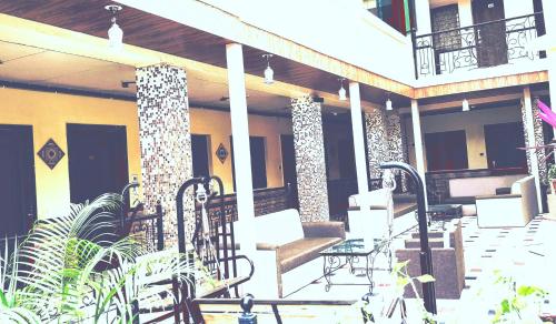 a patio with chairs and tables on a building at Hotel Saraswati in Mount Ābu