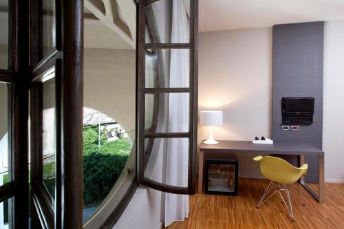 a room with a desk and a chair and a window at Alter Hotel in Barge