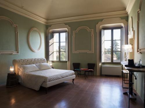 1 dormitorio con 1 cama y 2 ventanas en Antico Convento San Francesco en Bagnacavallo