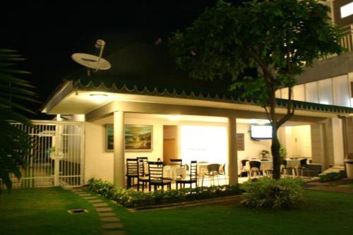 a house with a patio with a table and chairs at The Sriwijaya Hotel - Halal Hotel in Padang