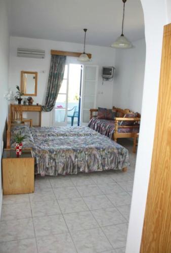 a bedroom with a bed and a table and a window at Mavromatis Studios in Naxos Chora