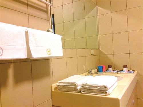 a bathroom with towels and a sink and a mirror at 1986 Travel Hall in Tainan