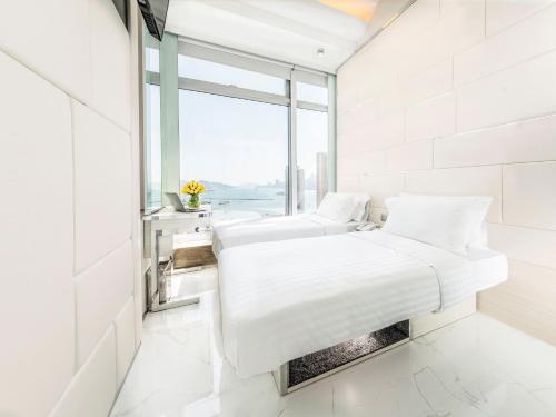 two beds in a white room with a window at iclub To Kwa Wan Hotel in Hong Kong
