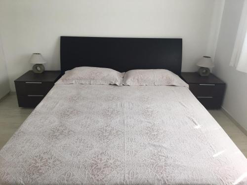 a bedroom with a large bed with two night stands at Sandy Beach Apartment 8 in Voroklini