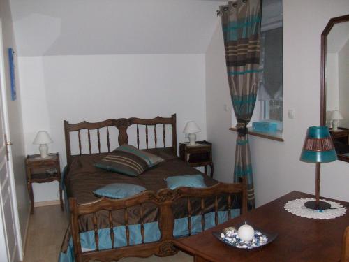 1 dormitorio con cama de madera y mesa en Chambres d'Hotes la Belle Taille, en Lassay