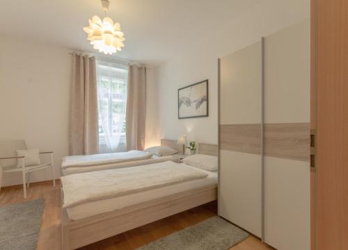 ブレッサノーネにあるAlbrechthausのベッドルーム1室(ベッド2台、シャンデリア付)