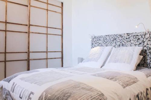 une chambre avec un grand lit avec des oreillers blancs dans l'établissement Appartement Vue sur le Vieux Port, à Marseille