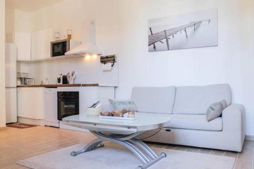 un salon avec un canapé blanc et une table dans l'établissement Appartement Vue sur le Vieux Port, à Marseille