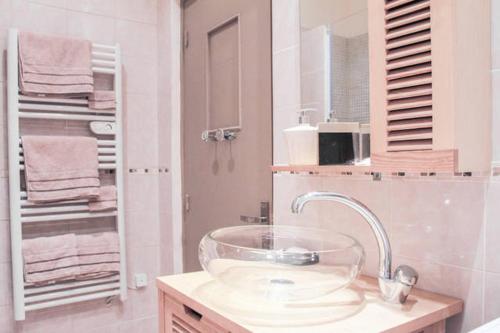 ein Badezimmer mit einer Glasschüssel auf einem Waschbecken in der Unterkunft Appartement Vue sur le Vieux Port in Marseille