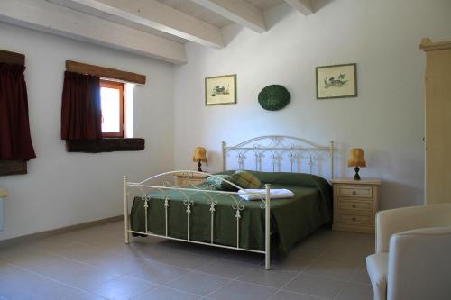 a bedroom with a bed and a table and a window at La Peschiera B&B in San Lorenzo del Vallo