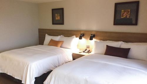two beds sitting next to each other in a hotel room at Just Sleep Kaohsiung Zhongzheng in Kaohsiung