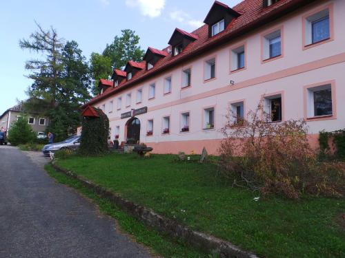 a large pink building with a red roof at Penzion Tomy Pihlov in Horní Planá