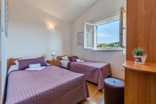 a bedroom with two beds and a window at Holiday Home Mirna Vala in Sevid
