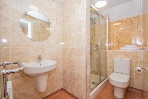 a bathroom with a toilet sink and a shower at Victoria Inn in Cowbridge