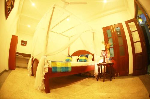 a bedroom with a bed with a canopy at Villa Bird Gate in Galle
