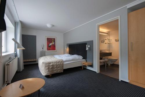 a hotel room with a bed and a bathroom at Hotel Koldingfjord in Kolding