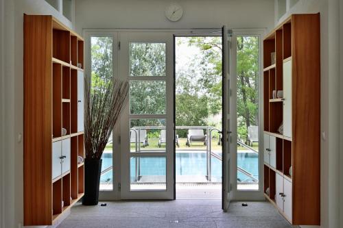 an open door with a view of a pool at Hubertus Hof Landhotel in Balatonfenyves