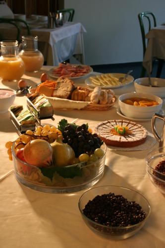 a table topped with bowls of different types of food at Hotel Ramoverde in Borgomanero