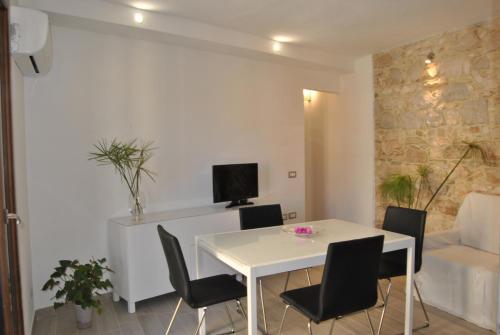 een witte eetkamer met een witte tafel en stoelen bij Casa Sant'Antoni in Baunei