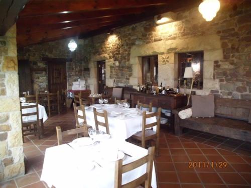 ein Restaurant mit weißen Tischen und Stühlen in einem Zimmer in der Unterkunft Casona Los Gamonales in Carreno